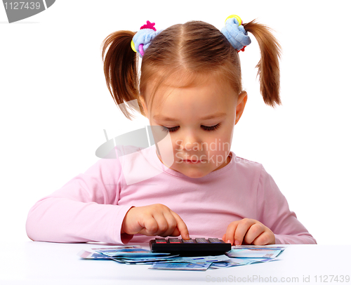 Image of Little girl plays with money