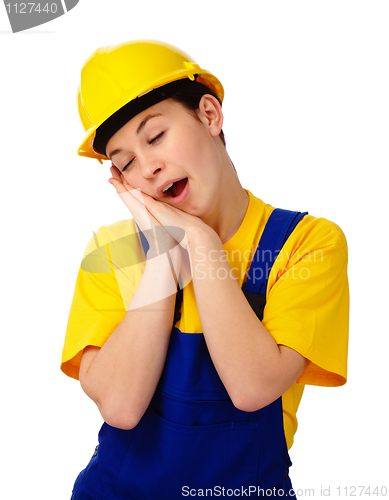 Image of Young woman in construction uniform is yawning