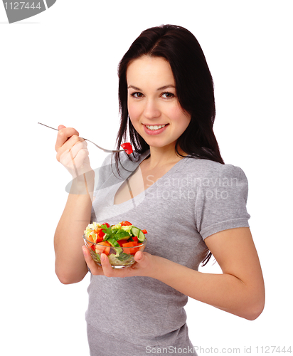 Image of Young attractive woman eats vegetable salad