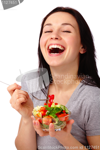 Image of Young attractive woman eats vegetable salad