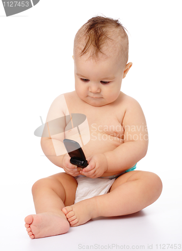 Image of Cute little baby plays with mobile phone
