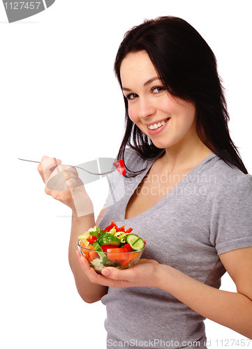 Image of Young attractive woman eats vegetable salad