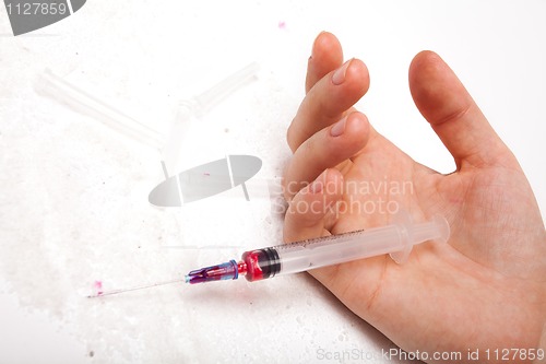 Image of Syringe in a palm of the addict