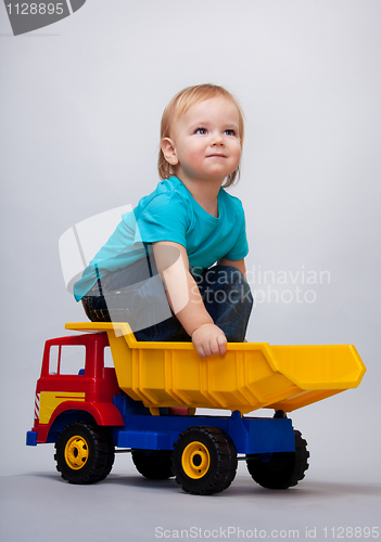 Image of Kid sitting on a toy truck