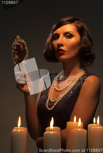 Image of Studio picture of a young woman looking in a mirror