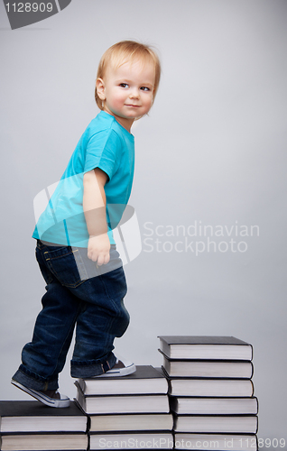 Image of Young man climbing on a ladder of books