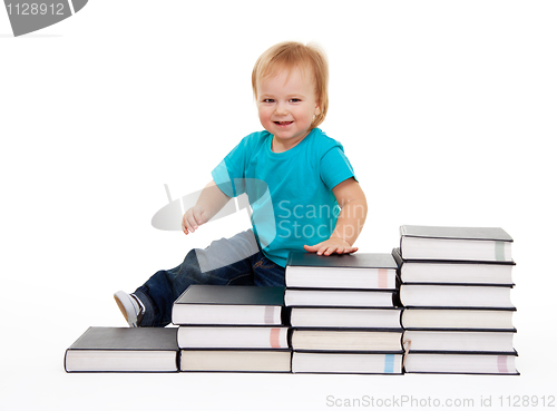 Image of Happy kid sitting on the steps of books