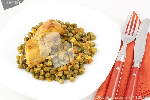 Image of Chicken meat with green peas, carrots and corns on table