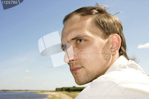 Image of The young man in the summer on river bank