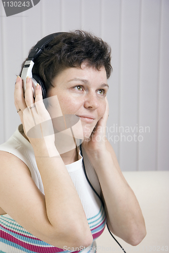 Image of The girl listens to music in ear-phones