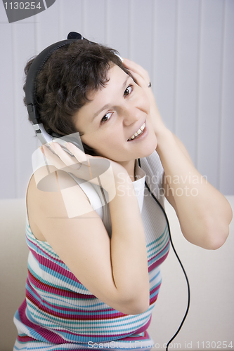 Image of The girl listens to music in ear-phones