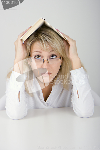 Image of The young woman hides under the book
