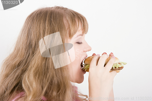 Image of The girl bites a hamburger