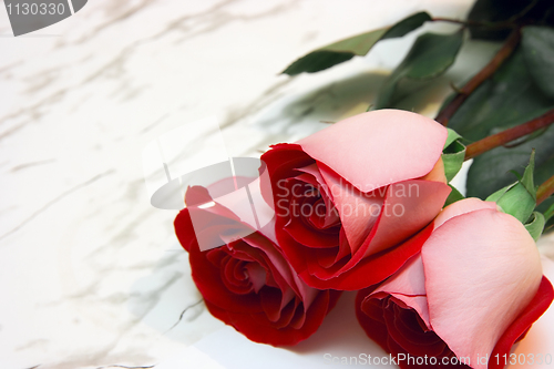 Image of Three roses on a marble table