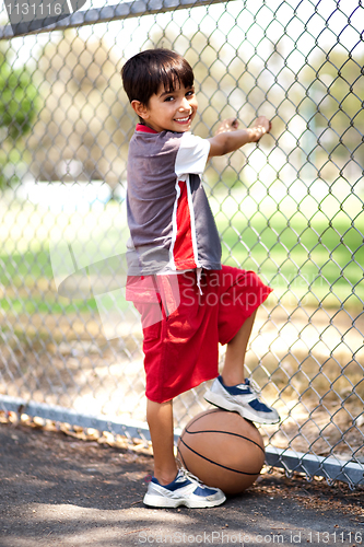 Image of Smart kid posing with basketball