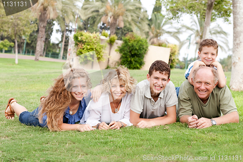 Image of Affectionate family lying in the park