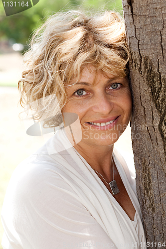 Image of Image of Portrait of a happy senior woman holding tree