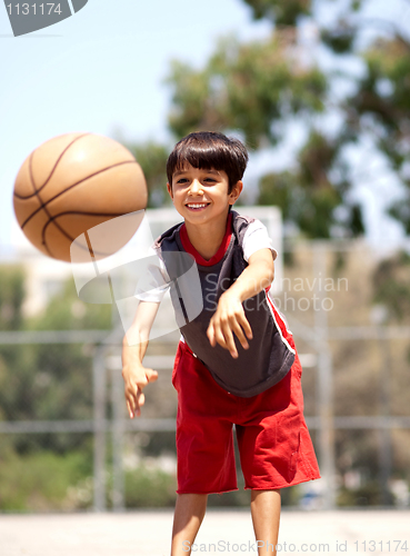 Image of Young boy passing basketball
