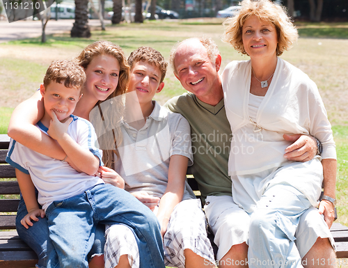 Image of happy family sitting on park bench
