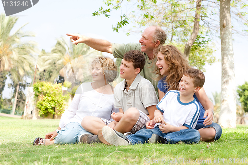 Image of potrait of grandfather pointing with family