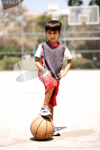 Image of Smart kid holding basketball under his leg