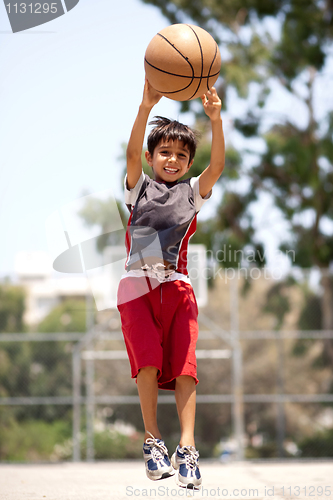 Image of Young basketball player jumping high