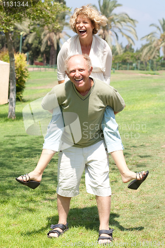 Image of image of Senior man giving woman piggyback ride