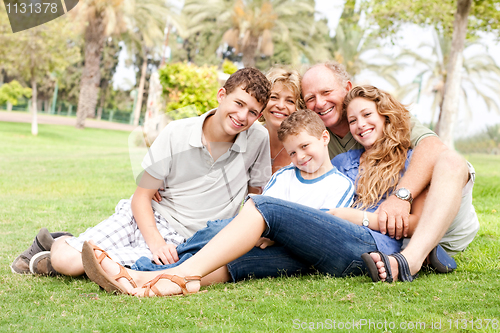 Image of Happy family relaxing in the park