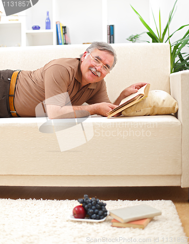 Image of Senior man relaxing and reading