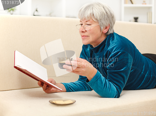 Image of Senior woman with book and coffee