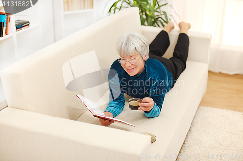 Image of Senior woman with book and coffee