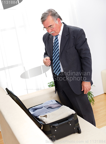 Image of Man looking at suitcase