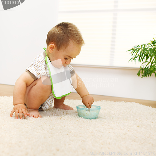 Image of Baby boy playing with food