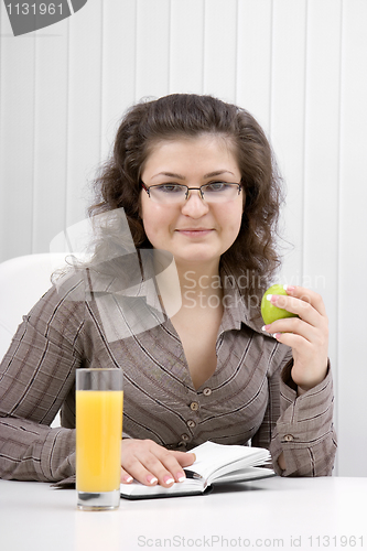 Image of business woman with a notebook and an apple