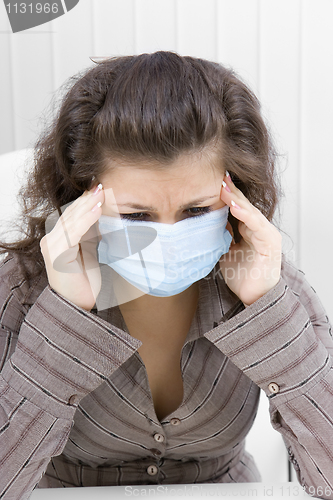 Image of The sick girl with medical mask with sad eyes