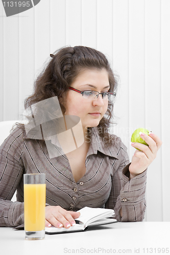 Image of business woman with a notebook and an apple
