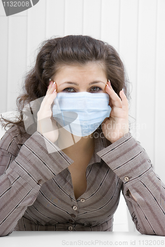 Image of The sick girl with medical mask with sad eyes