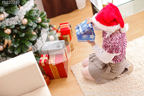 Image of Girl in christmas, looking inside gift box