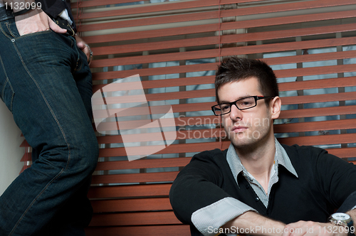 Image of Young student with glasses sitting in window with man in jeans