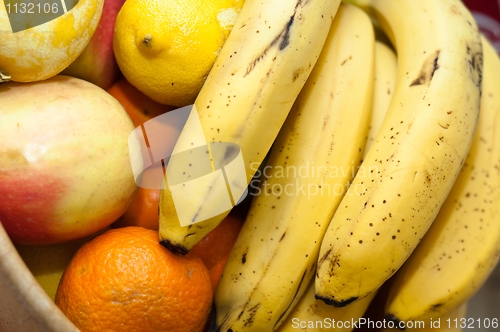 Image of orange, banana, and otherfresh fruits in wooden dish