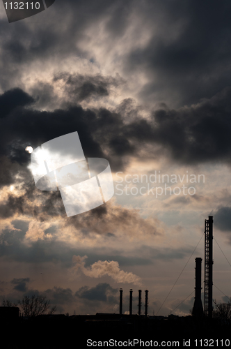 Image of silouette of a powerplant with smoke coming out of chinney and s