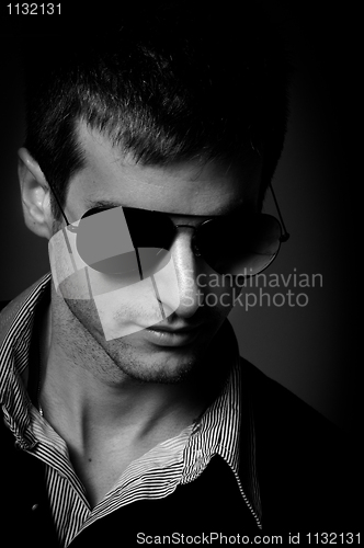 Image of Closeup of a young man wearing sunglasses in black and white