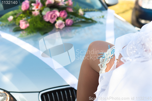 Image of Leg of the bride with wedding garter on car