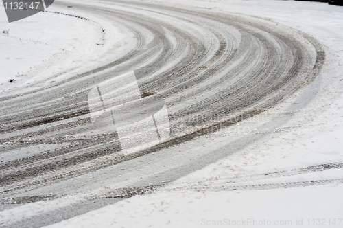 Image of Curve in road covered by snow with track