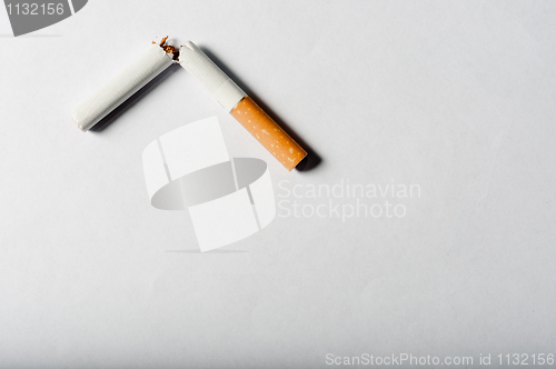 Image of Broken cigarette on white background with harsh shadows