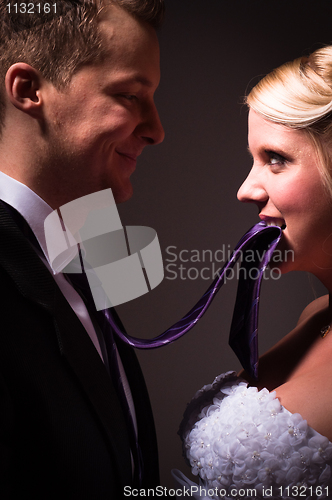 Image of Beautiful young bride holding her groom on a leash