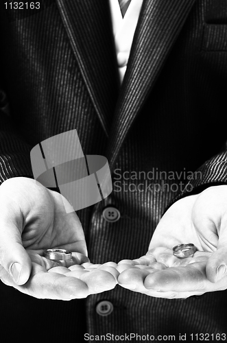 Image of Man holding engagement rings in black and white
