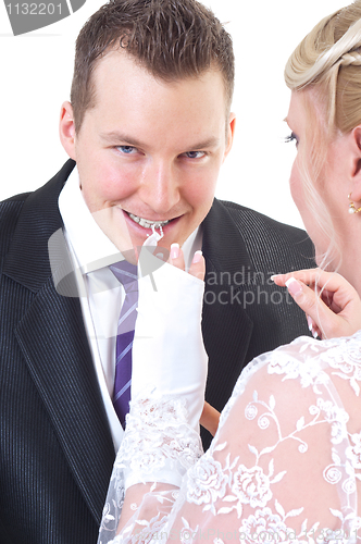Image of Groom undressing bride while taking off her gloves