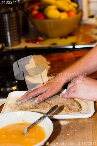 Image of Fresh meat with flour and crumb on in with the hands of a cook w