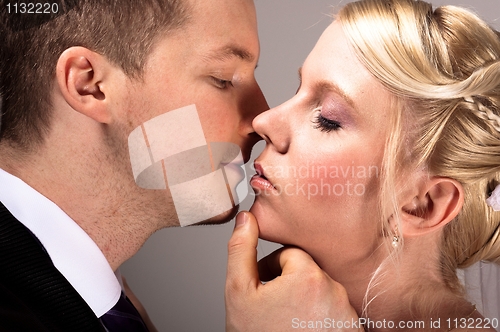 Image of young couple in wedding wear kissing